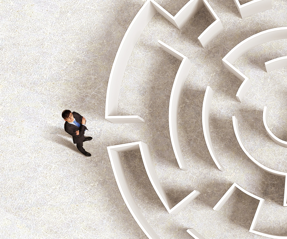 Top view of successful businessman standing near the entrance of labyrinth